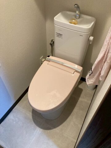 施工前のトイレ。TOTO製便器にINAX製ピンク色の旧型ウォシュレット便座が設置されている。