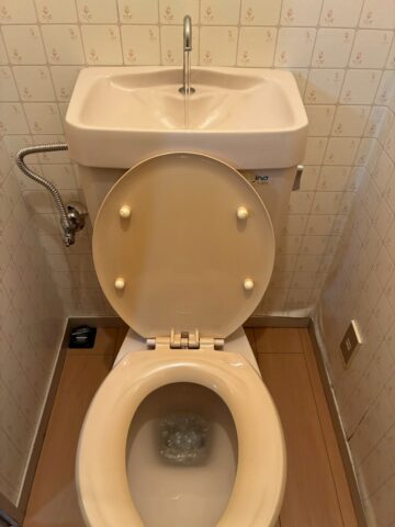 施工前の旧トイレ全景。INA製ベージュ色の便器・タンク一体型