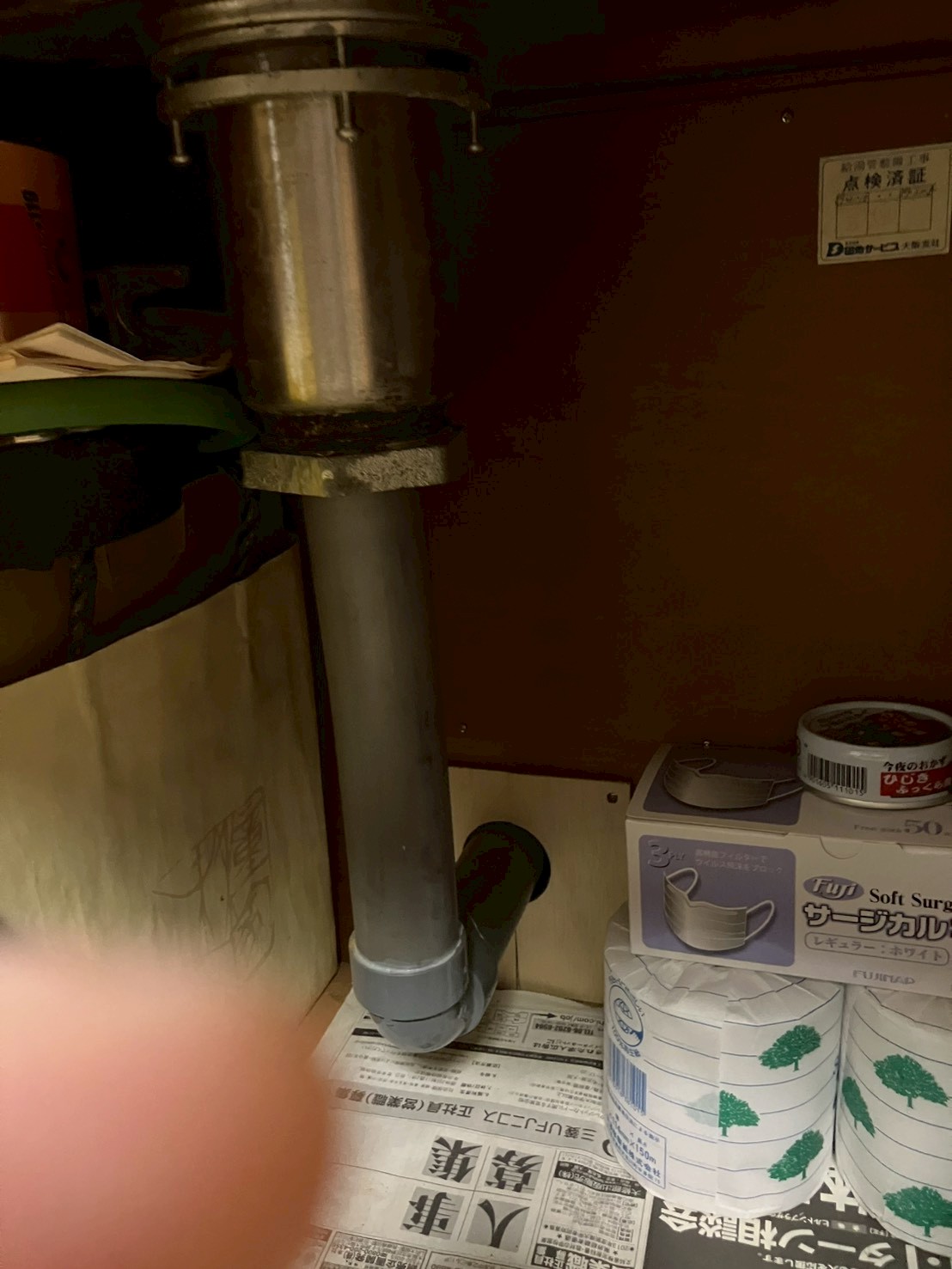 シンク下収納内の排水管の状態。金属製縦型排水トラップと塩ビエルボが確認できる