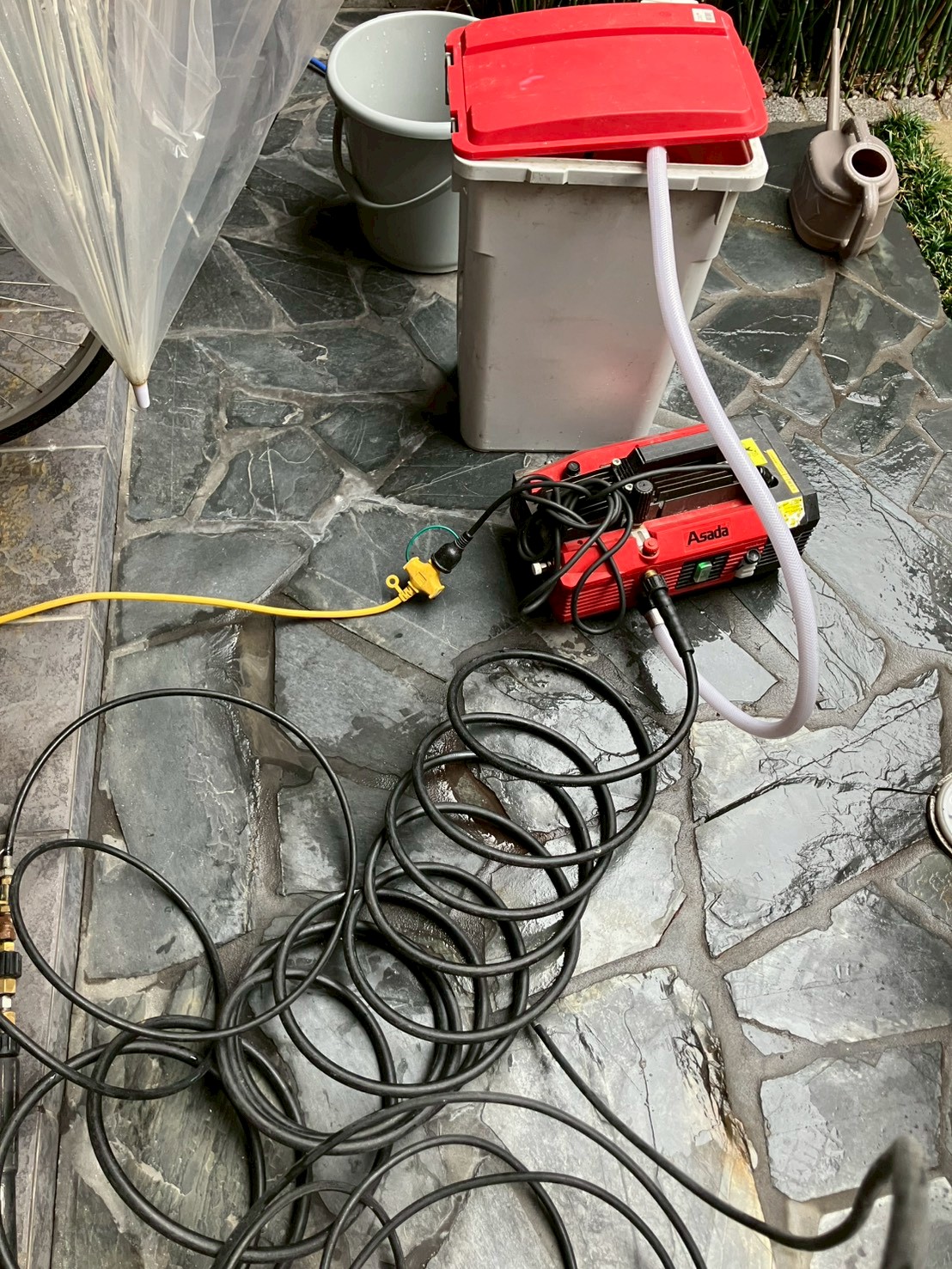 屋外テラスに設置されたAsada製高圧洗浄機と大量の高圧ホース。排水タンクも用意されている