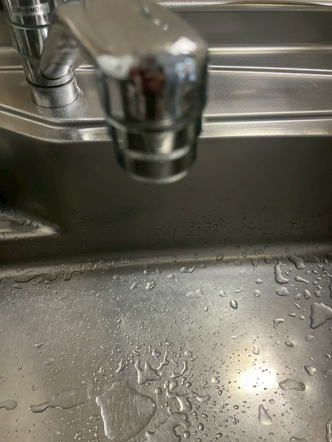 吐水口根元から水が滴り落ちている水漏れ箇所のアップ