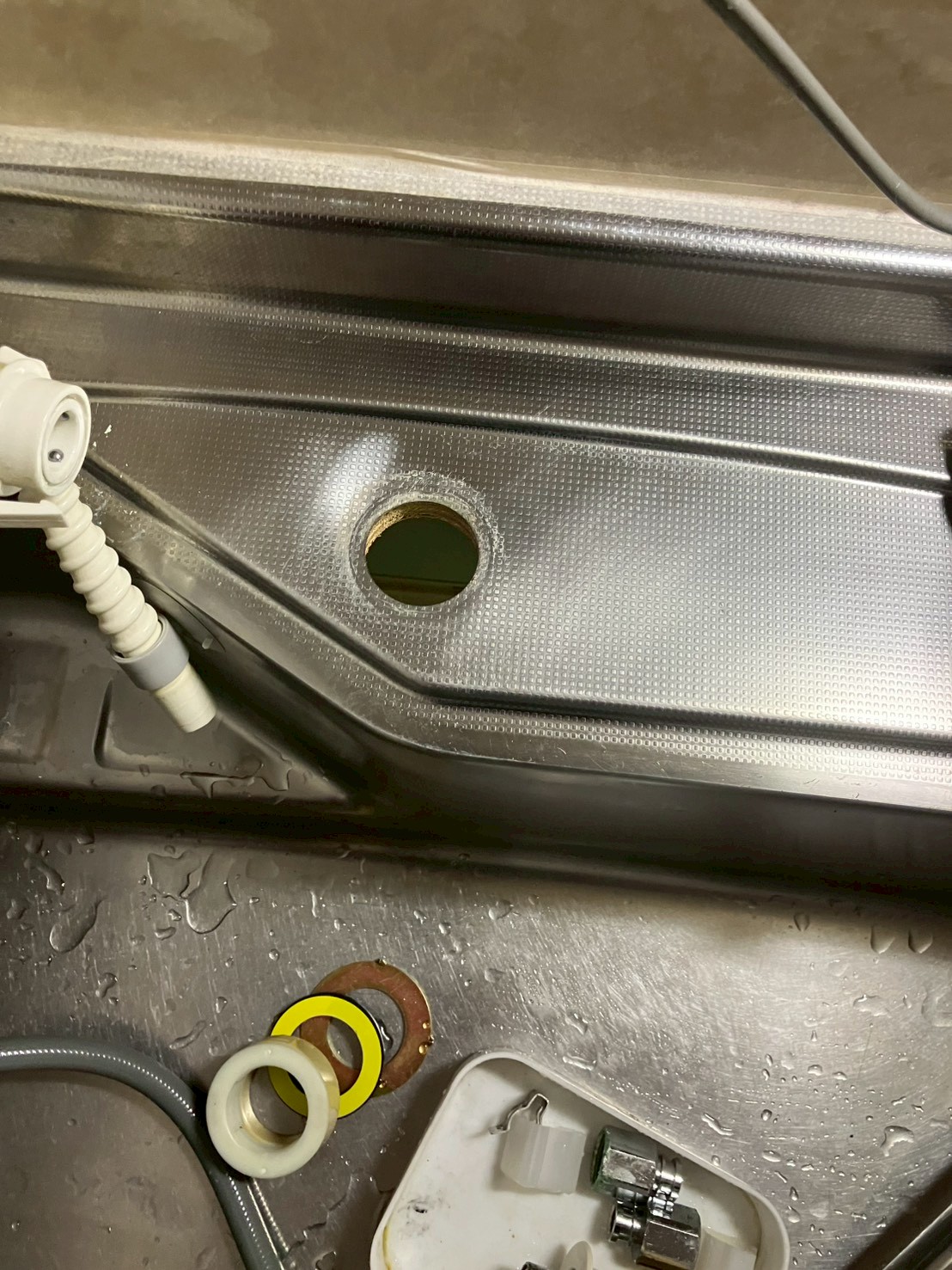 旧水栓を取り外したシンク天板の取付穴が露出した状態