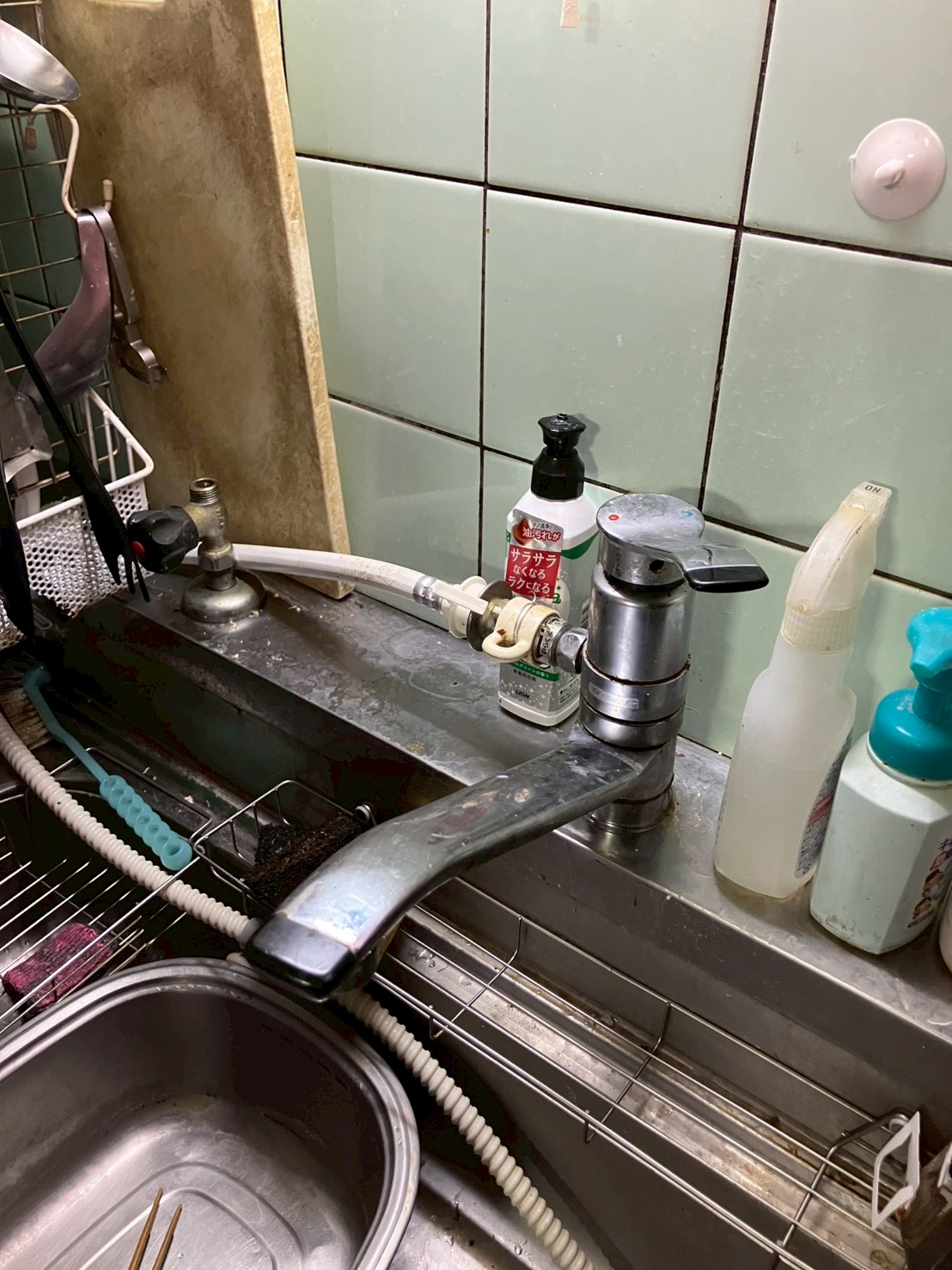 施工前のキッチン。古いシングルレバー混合水栓と分岐水栓が設置され、本体や台まわりが錆・水垢で著しく劣化している