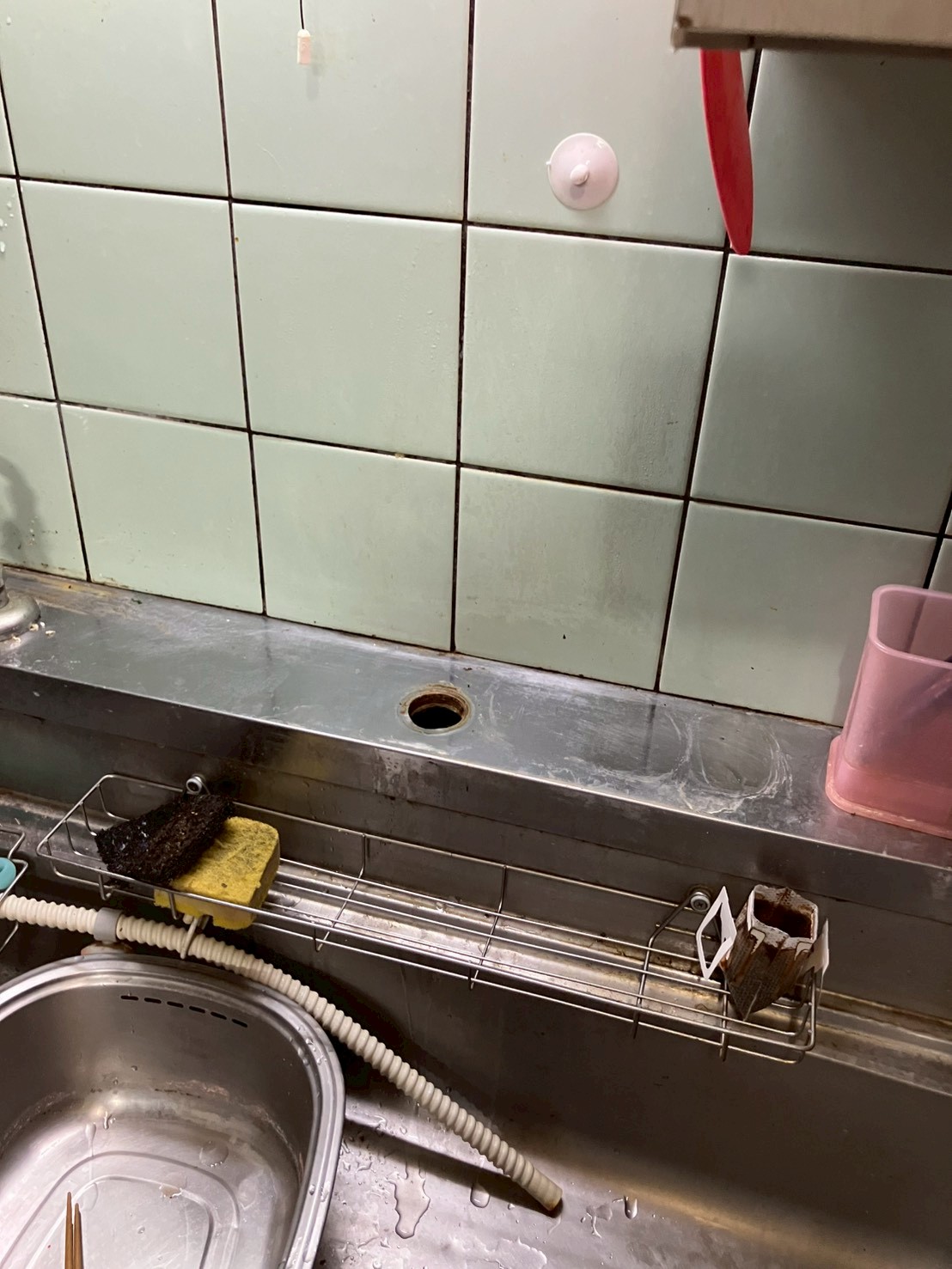 古い水栓を取り外した後の天板。取付穴のみが残り、まわりが錆・水垢で汚損している状態