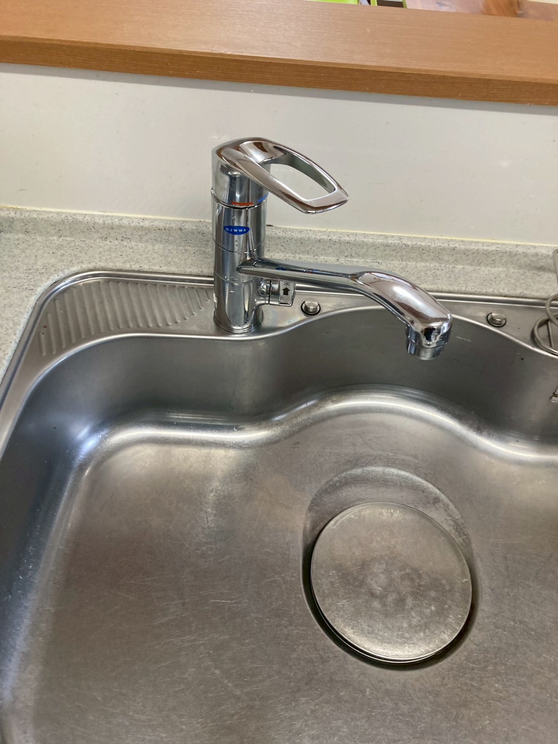 施工完了後のキッチンシンク全体。新しいシングルレバー混合水栓が清潔感よく設置されている