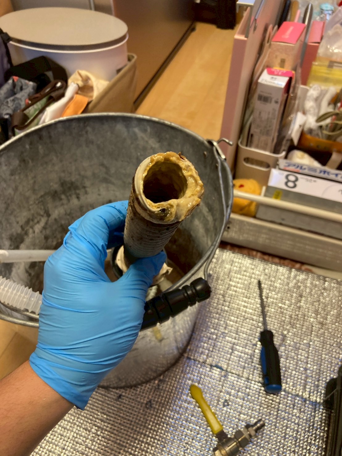 取り外した蛇腹管の内部。油脂とスケールが厚く付着し、管の内径が大幅に狭くなっている様子