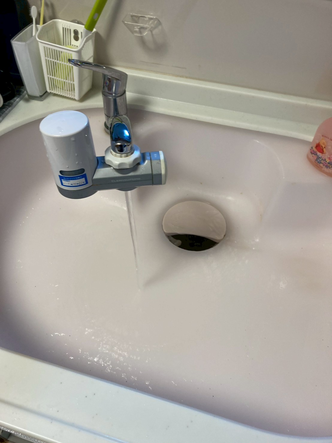 施工完了後のキッチンシンク。水を流して動作確認中。スムーズに排水できている