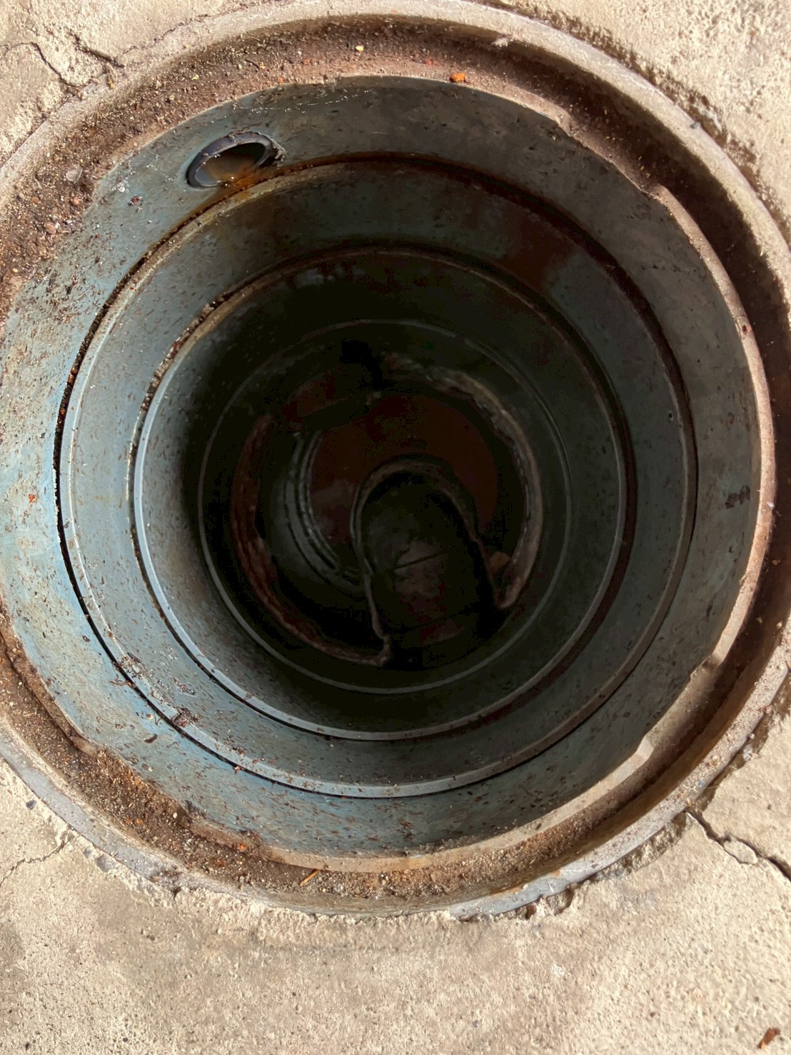 屋外排水桝の内部。油脂と汚泥が堆積してほぼ満水になっている詰まりの状態