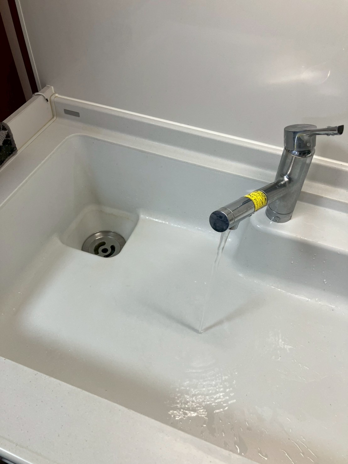 施工完了後のキッチンシンク。水を流して排水確認中。スムーズに排水されている