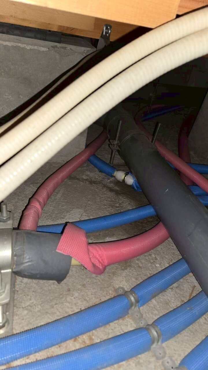 床下空間に青(給水)・赤系・白波型のポリ管が複数本配管されている様子