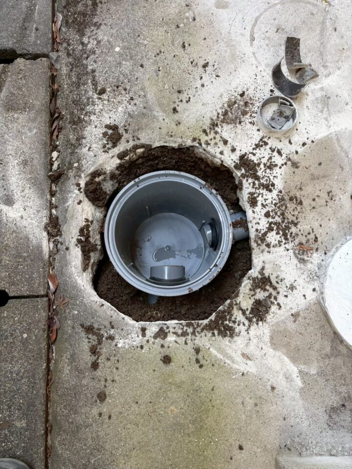 土間コンクリートを円形に斫り、新しい桝を埋設している施工中の様子