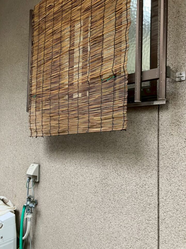 外壁沿いに新設された配管と洗濯機用蛇口(施工後)