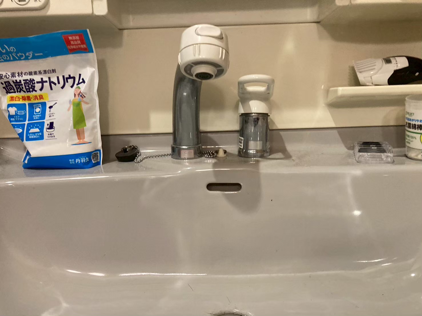 施工前の洗面台上面。旧シングルレバー水栓と右横に浄水器アダプターが設置されていた状態