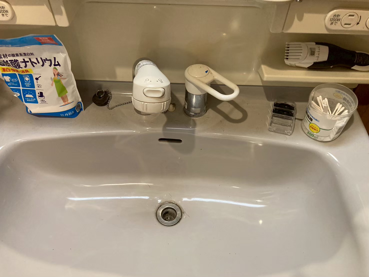 施工前の洗面台上面。旧シングルレバー水栓の本体が傾いて取付部が劣化している状態