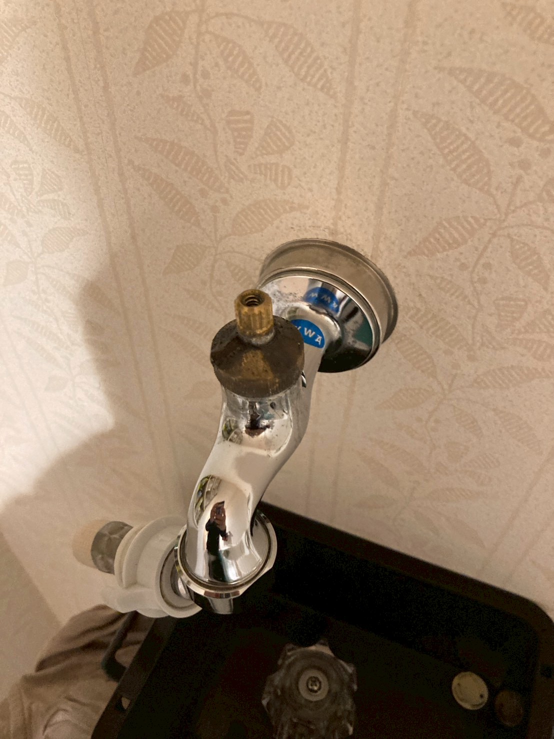 洗濯水栓を取り外した状態。壁から銅管の端部が露出し、水垢や錆が付着している