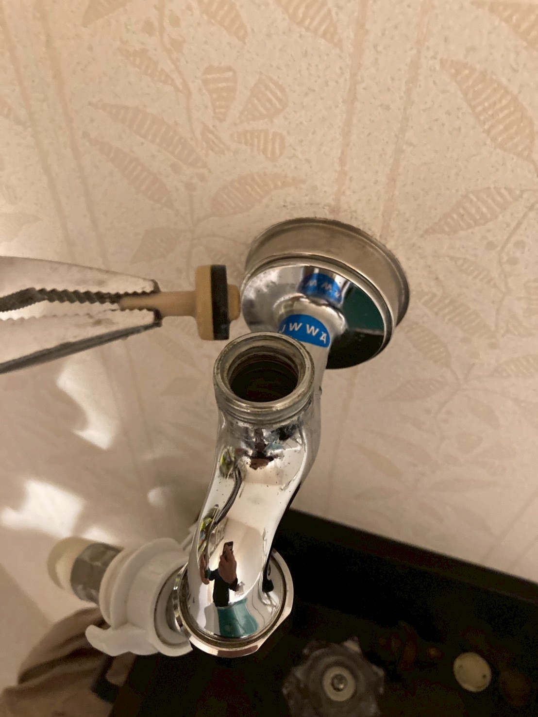 ペンチで古いパッキン（Oリング）を取り外している作業中の様子