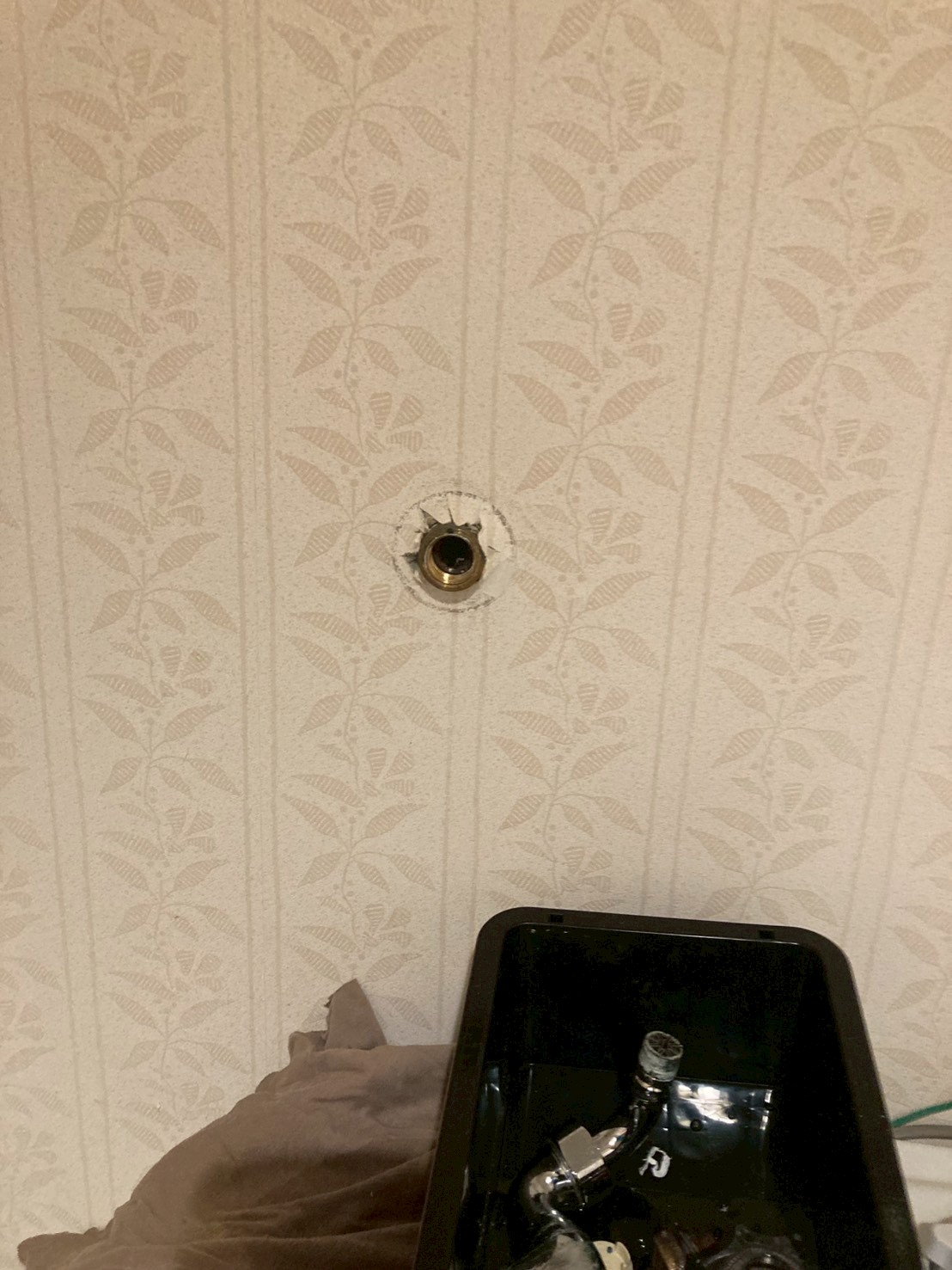 洗濯水栓取り外し後の壁面。給水管の銅管端部のみが残った状態