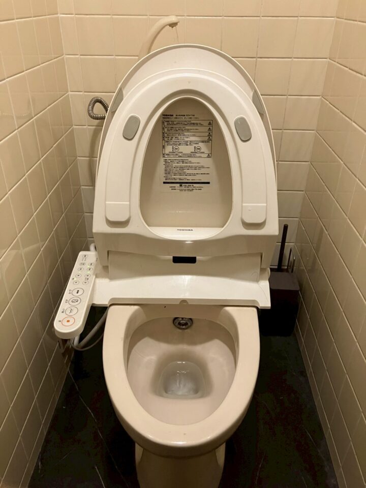 1階トイレの全体。TOSHIBA製ウォシュレット付き便器とベージュのタイル壁
