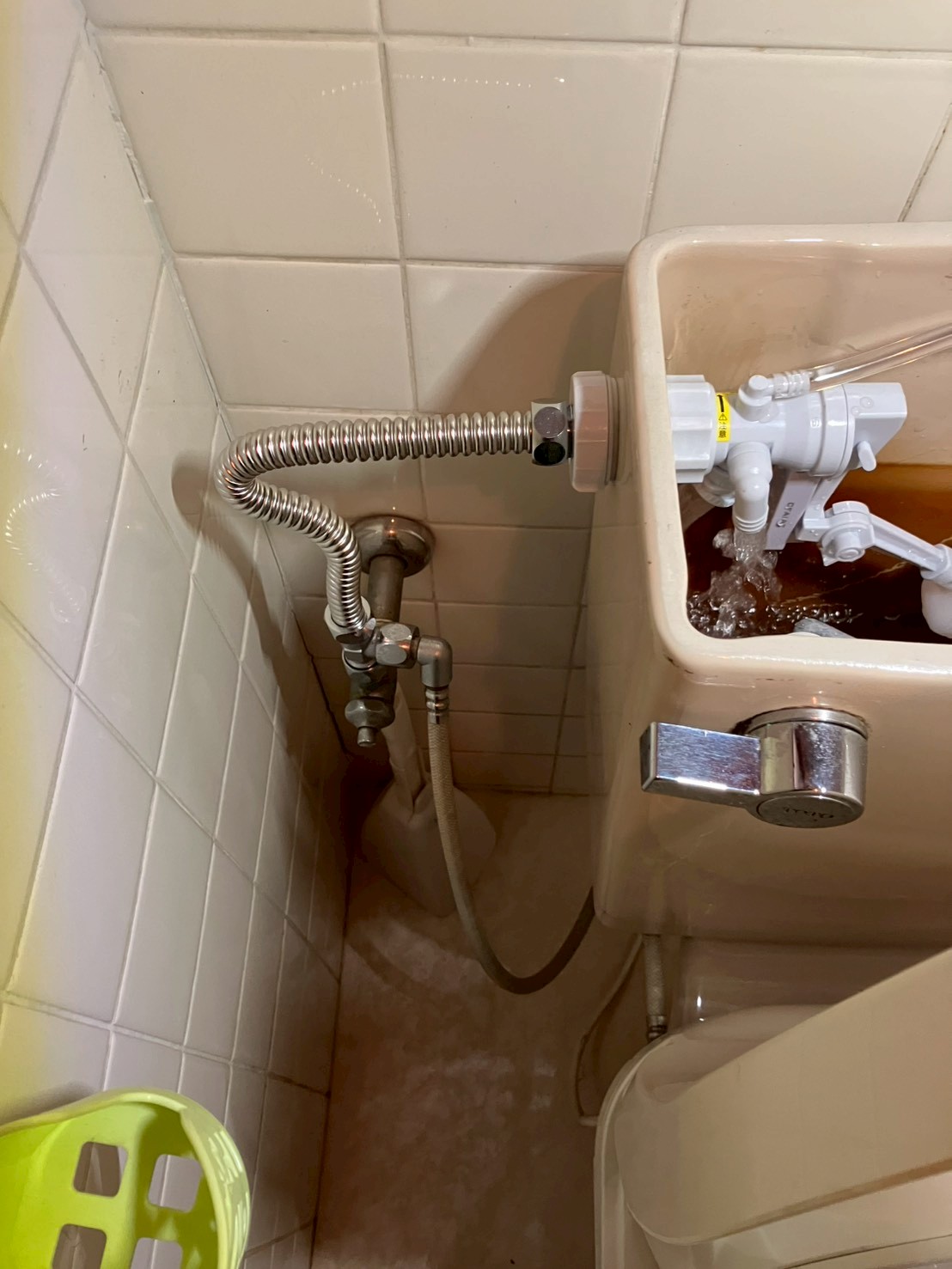 施工完了後の外観。新しいステンレス製フレキ管が壁からタンクへきれいに接続されている