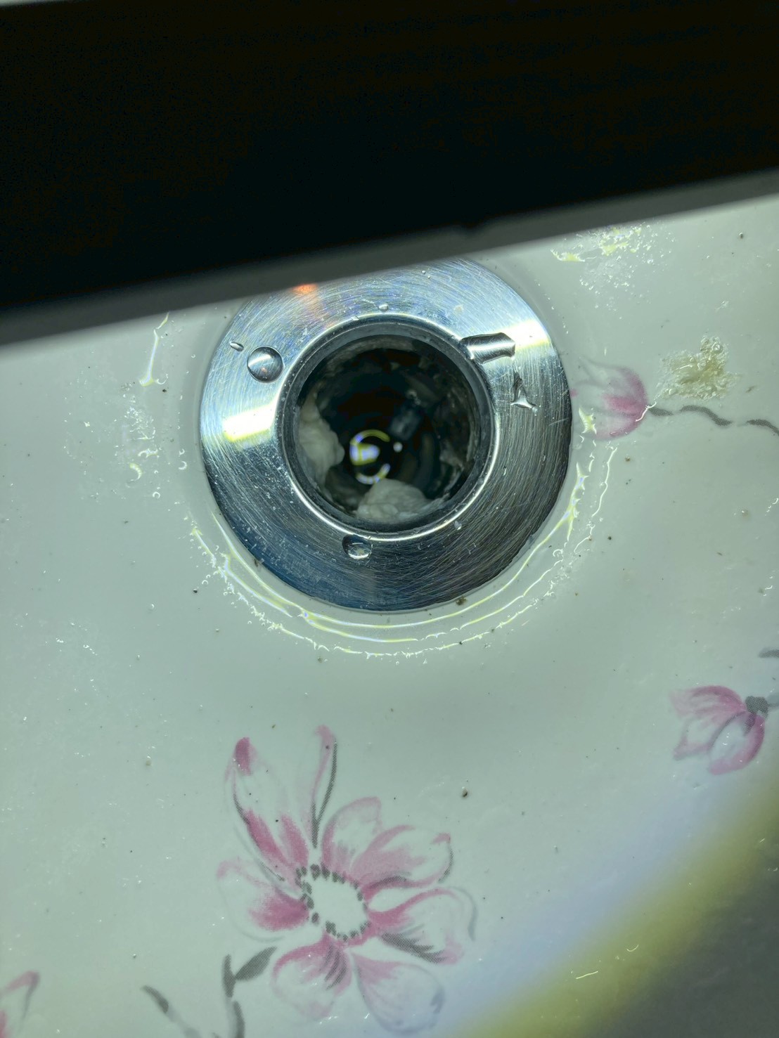 排水口の内部を接写。白い石鹸カス・カルシウムスケールが管内に詰まっている様子