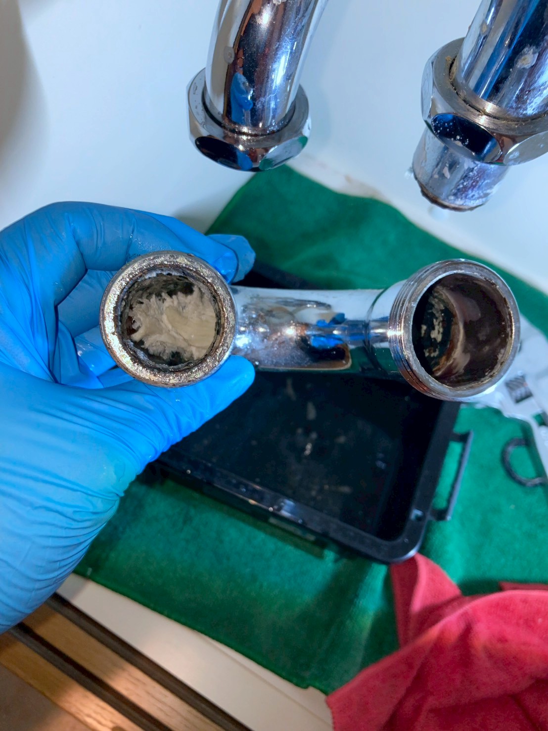 取り外したPトラップ管の内部。黒い汚れと石鹸スケールが内壁にびっしり付着している様子