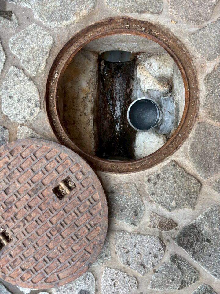 排水枡の内部からホースを挿入して高圧洗浄の準備