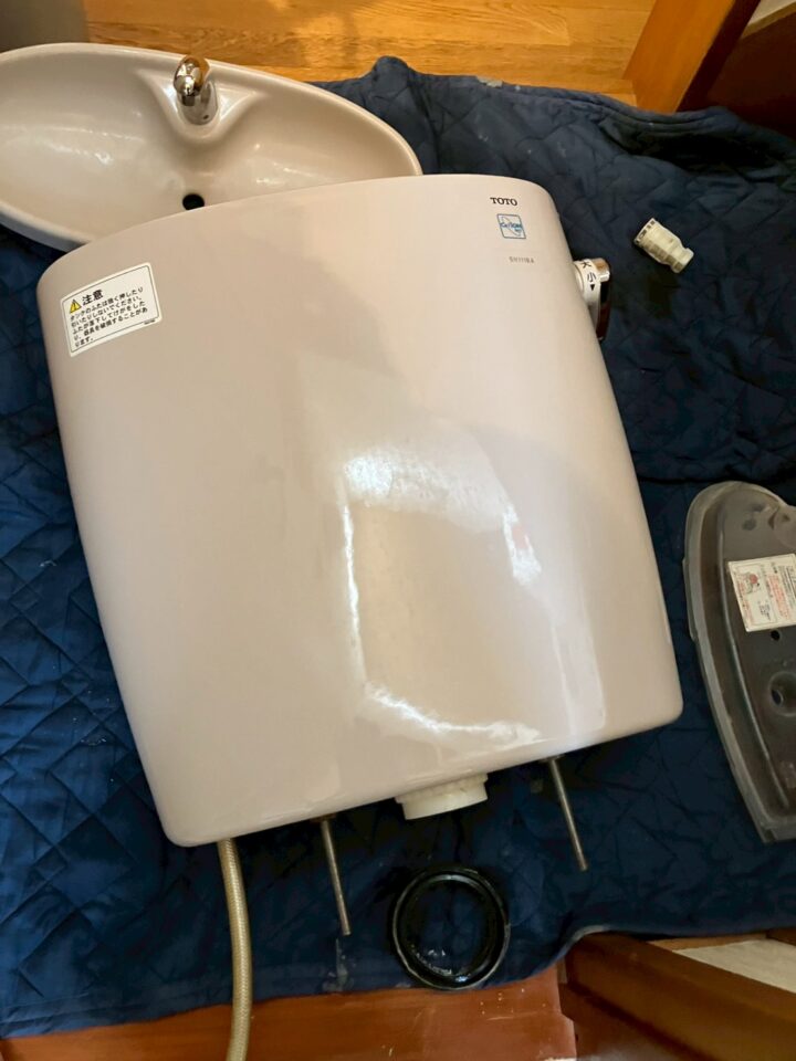 取り外したTOTO製タンク（SH1118A）をビニールシートに置いた状態"