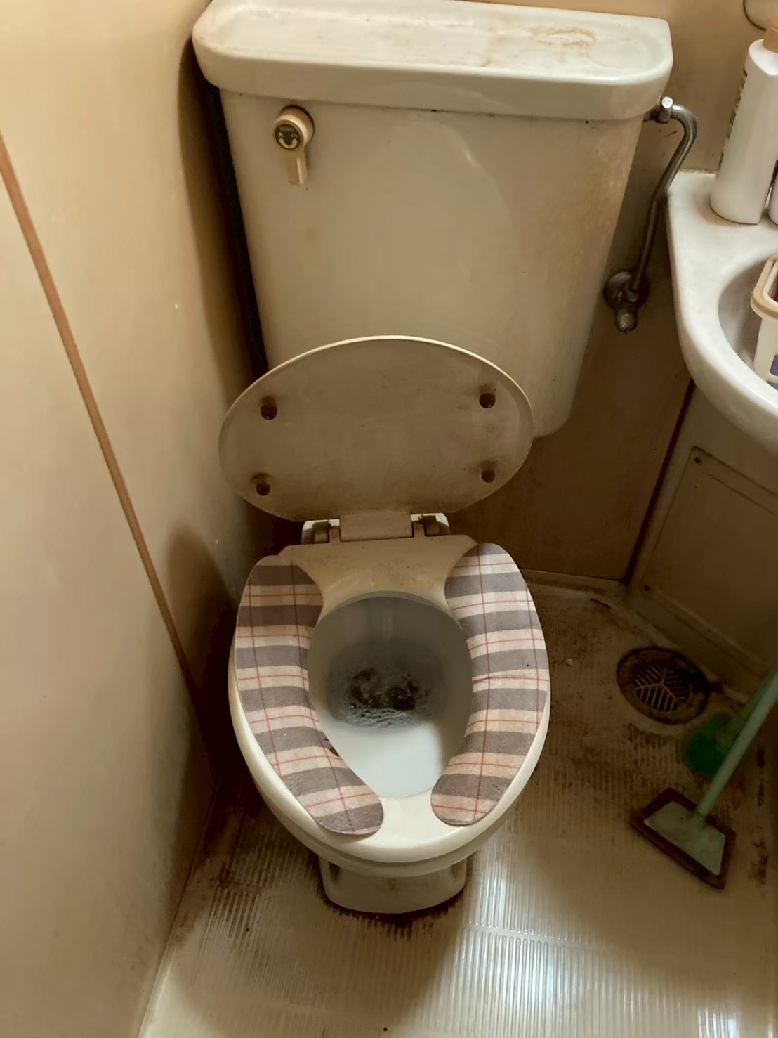 施工前のトイレ全体。TOTO製旧型ロータンクトイレ。便器内に水が大量に溜まり流れ続けている状態