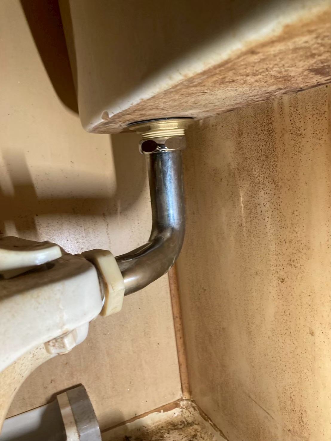 タンク底部に新しいステンレス製L字連絡管を取り付けた状態。光沢のある新品部品が確認できる